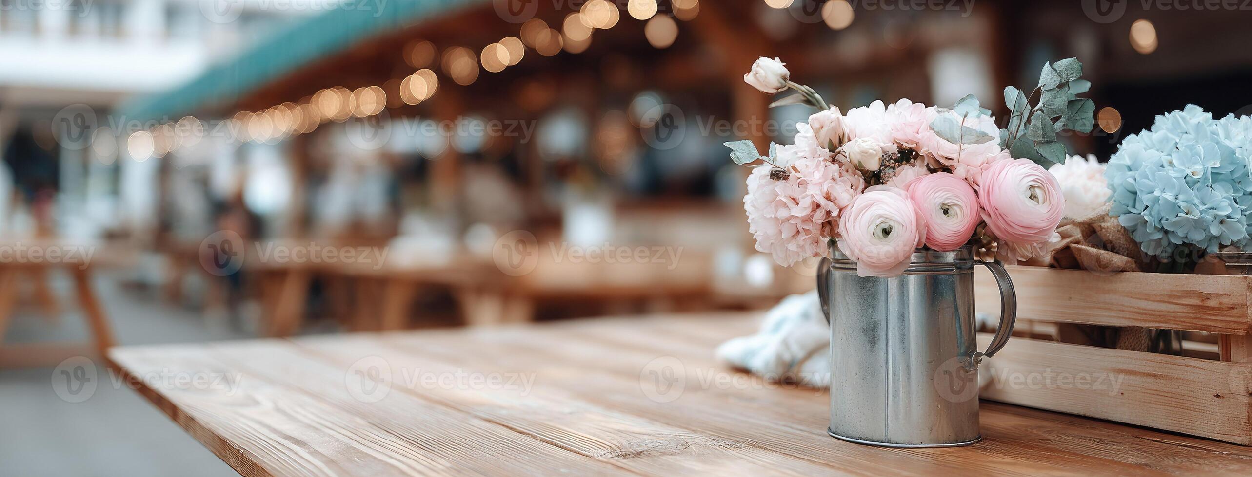 A wooden table with flowers in a metal bucket photo