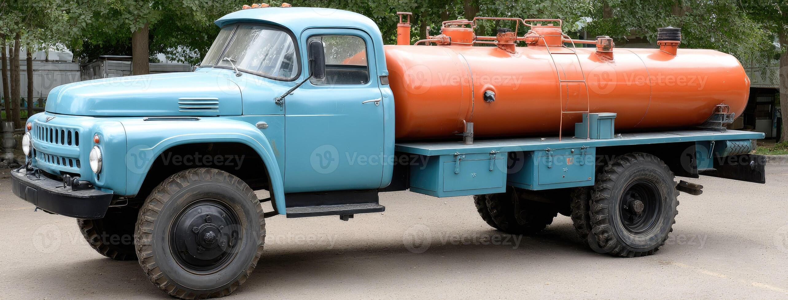 An old truck with an orange and blue tank photo