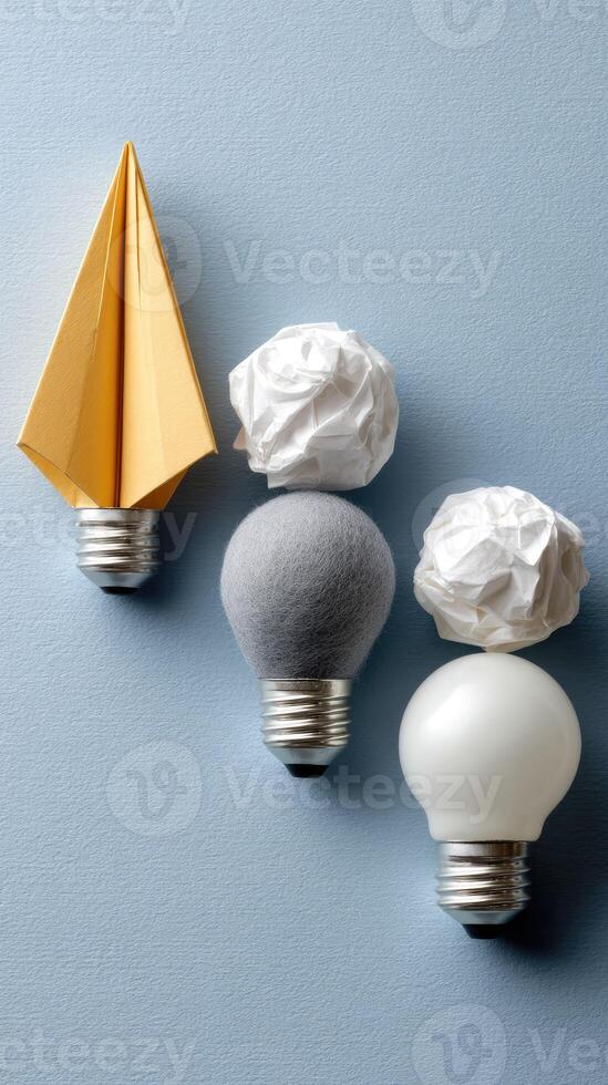 Three light bulbs with origami paper on them photo