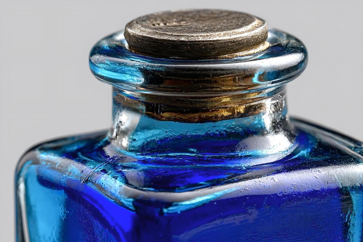 Antique blue glass ink bottle with metal cap close up photo