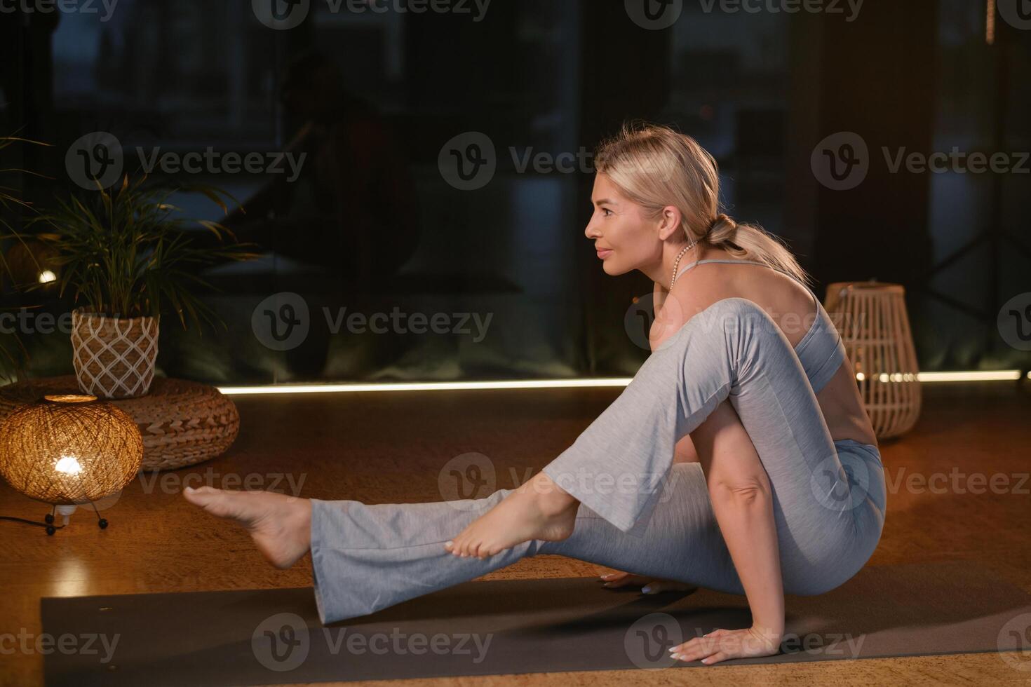 Dynamic yoga practice showcasing a woman performing an advanced pose in a serene and well-lit indoor studio environment during a peaceful evening session... photo