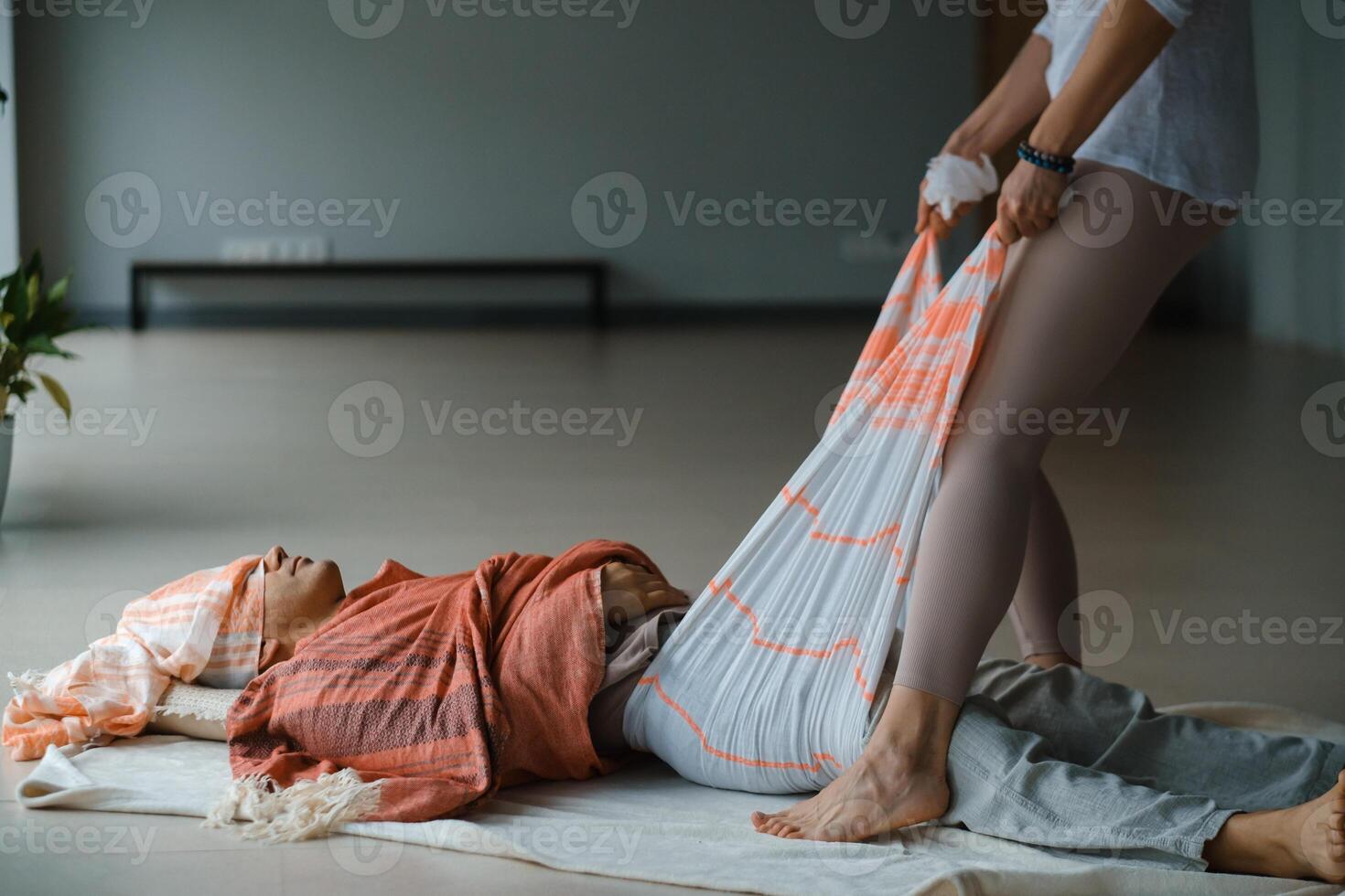 Individual receiving gentle support during a wellness session in a tranquil indoor setting with calming colors and natural light in the early afternoon. photo