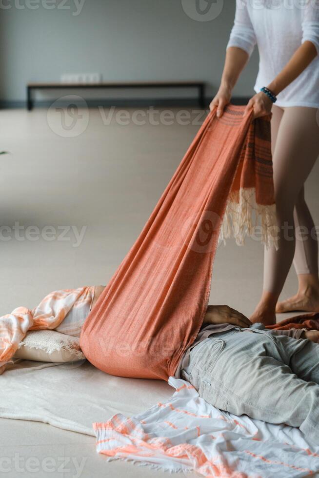 Yoga instructor prepares a class space with props and materials in a serene indoor studio environment during a morning session.. photo