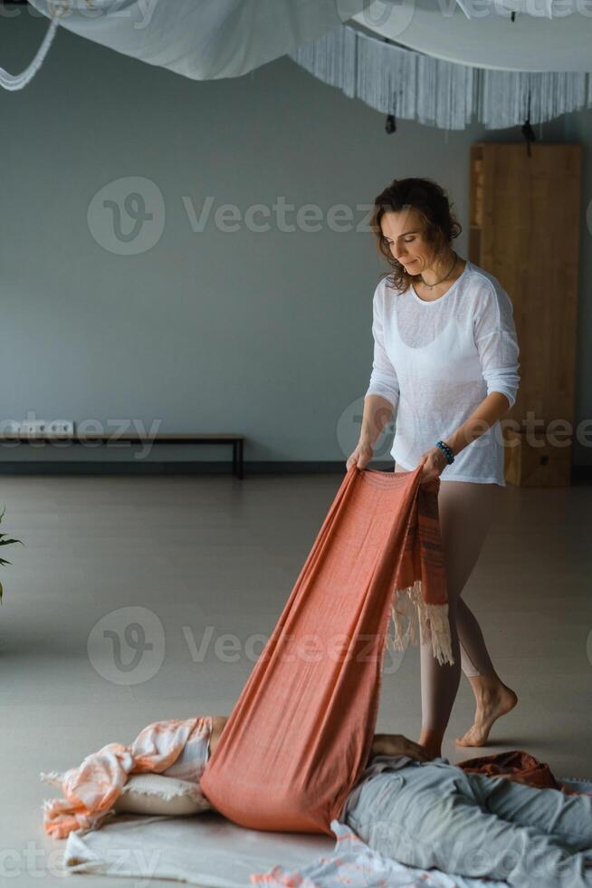 Yoga instructor prepares a class space with props and materials in a serene indoor studio environment during a morning session. photo