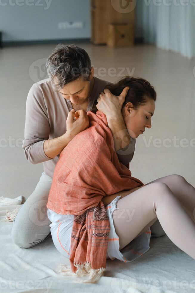 Couple engaging in a warm embrace during a morning meditation session in a bright, serene studio space photo