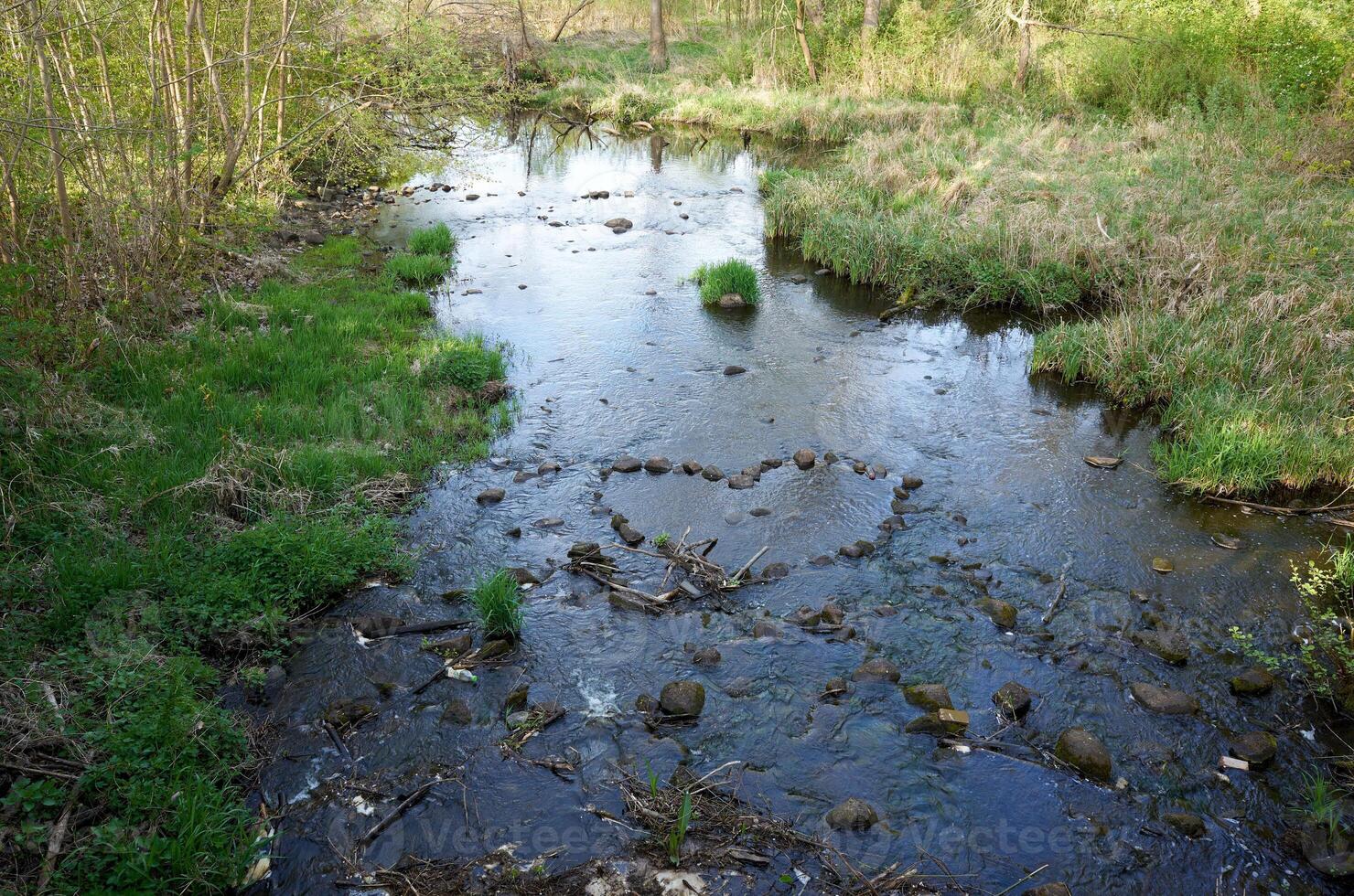 Body of water with a heart shape drawn in the mud photo