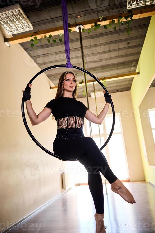 Woman in black Sitting On Aerial Hoop photo