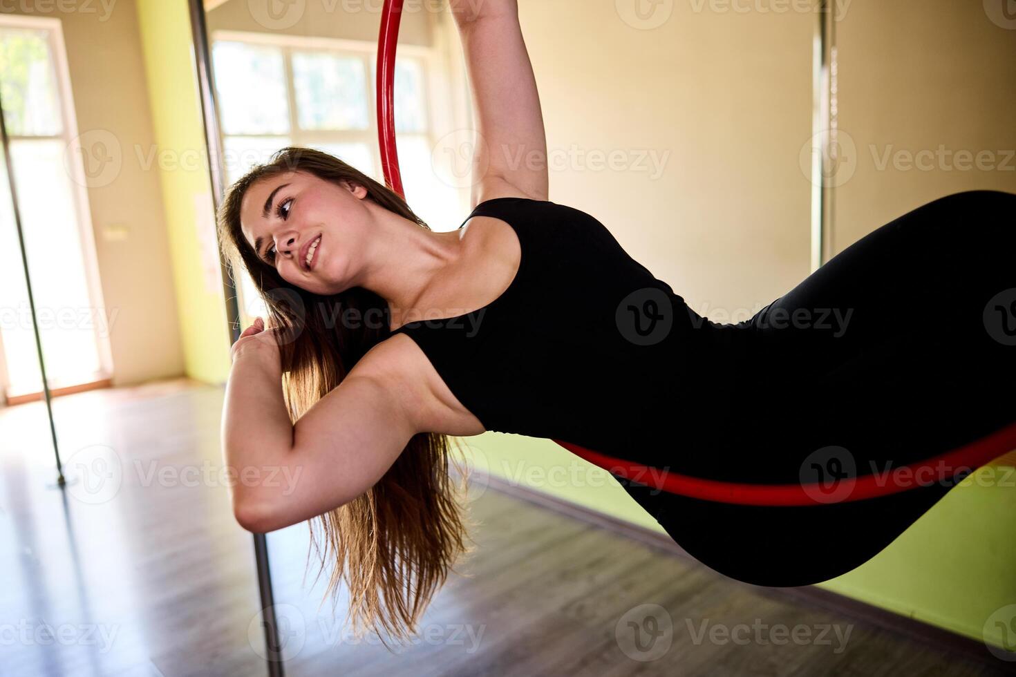 Smiling Woman Doing Acrobatics On Aerial Hoop photo