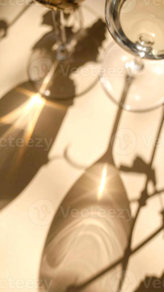 Shimmering Reflections and Delicate Shadows of Glassware on a Sandy Surface During a Sunny Afternoon Gathering photo