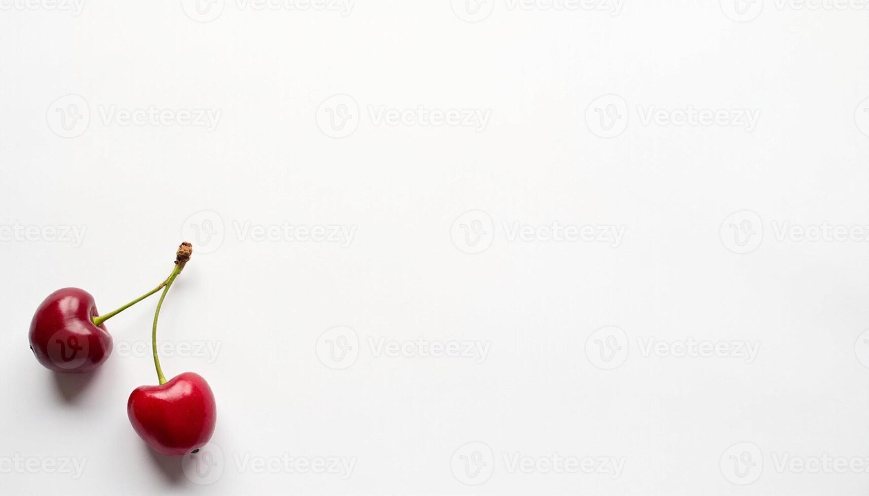 Two cherries positioned at distance on clean surface. photo
