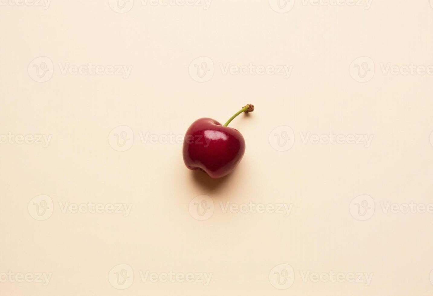 Bright cherry with strong stem placed diagonally on beige surface. photo