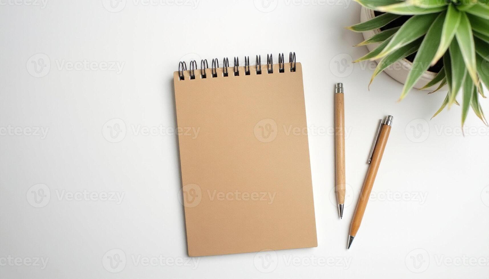Notebook and pencil flat lay with tropical leaves and modern minimal design. photo