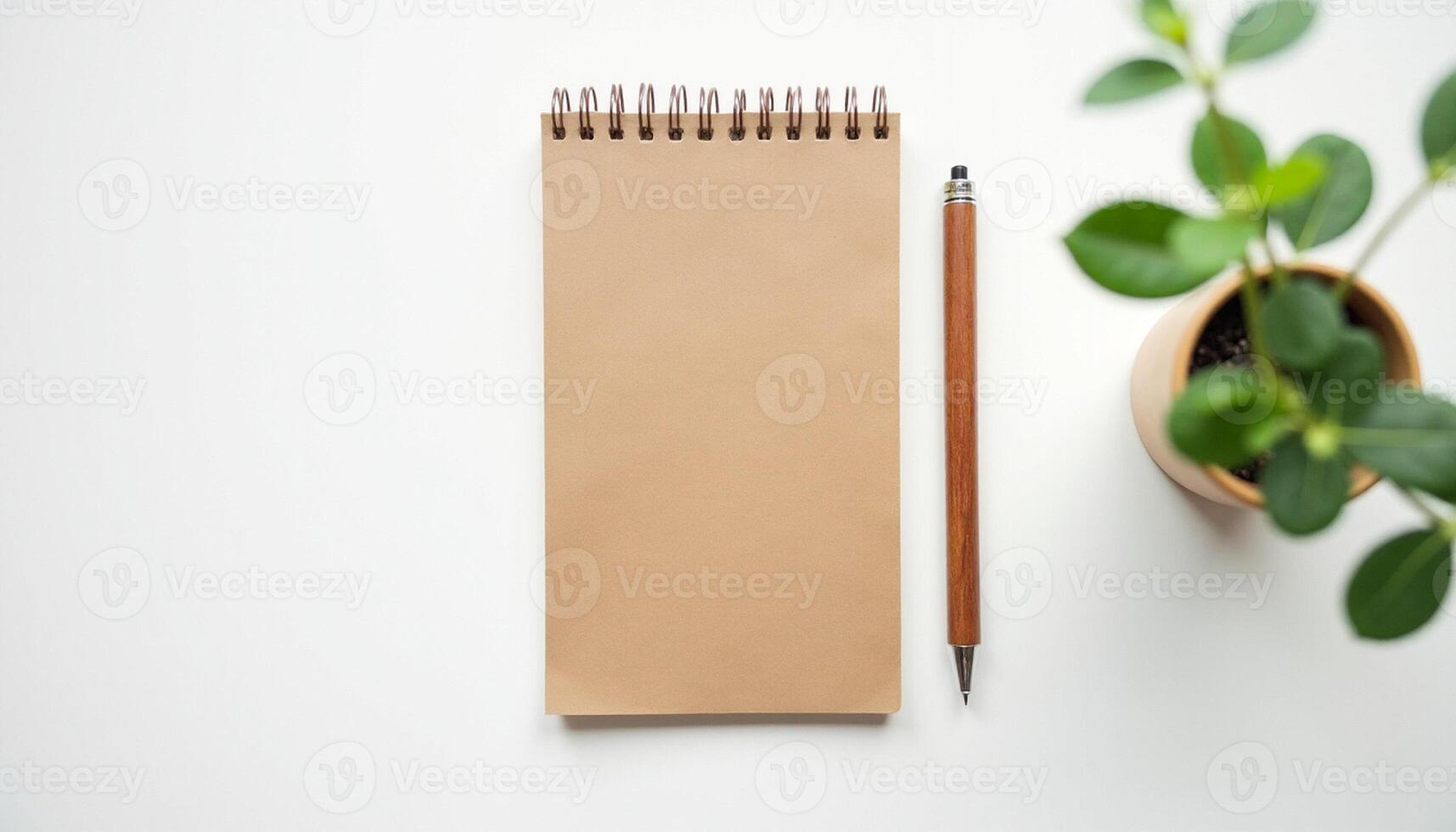 Kraft notebook and pencil surrounded by green plants in creative layout. photo