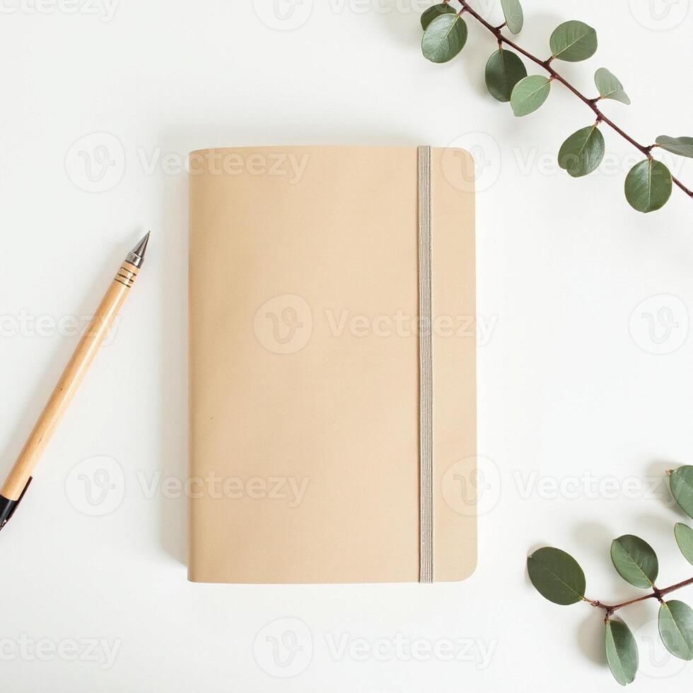 Creative flat lay with kraft notebook, pen, and scattered foliage. photo