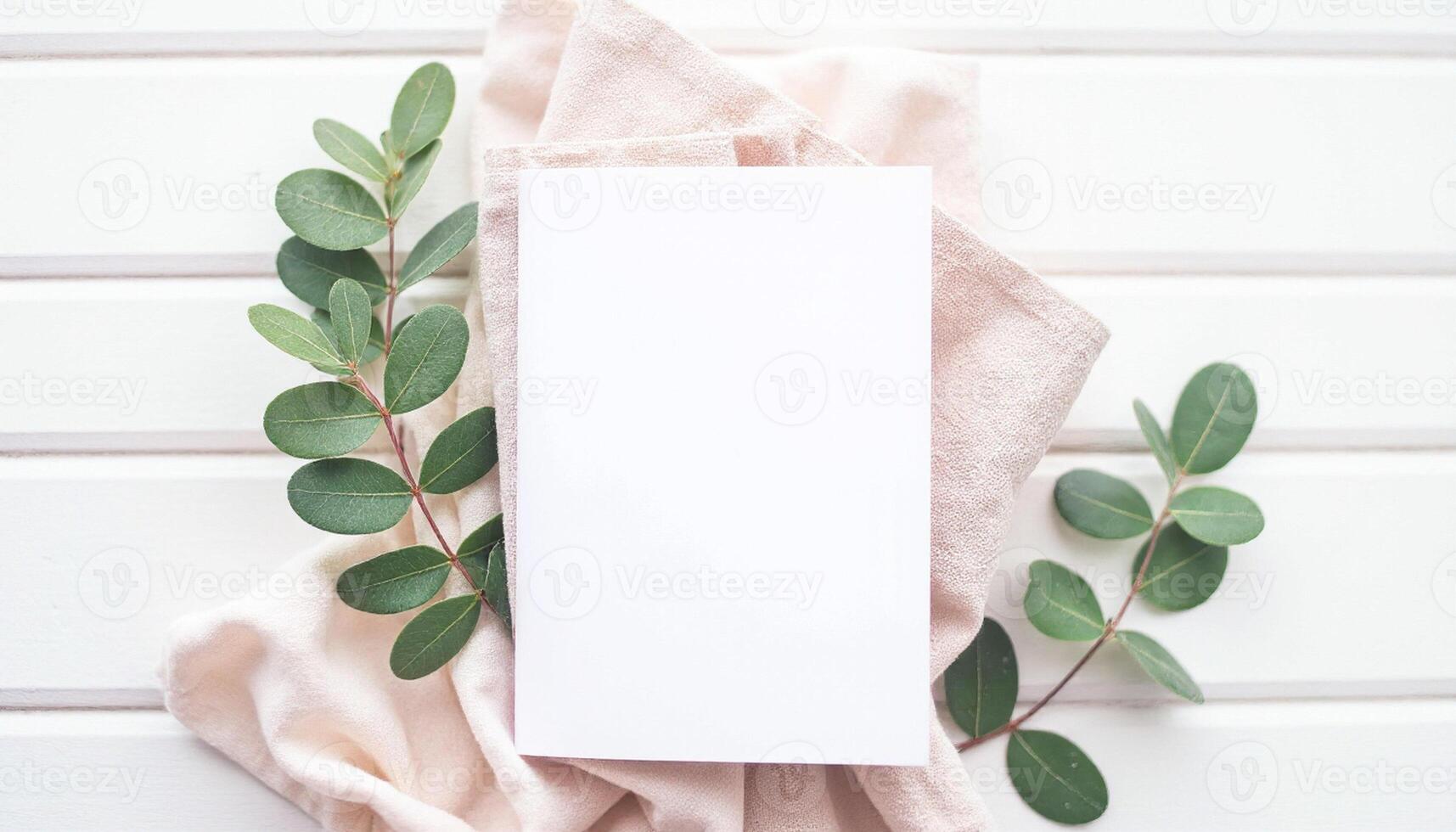 Blank white card with eucalyptus leaves on white wooden background photo