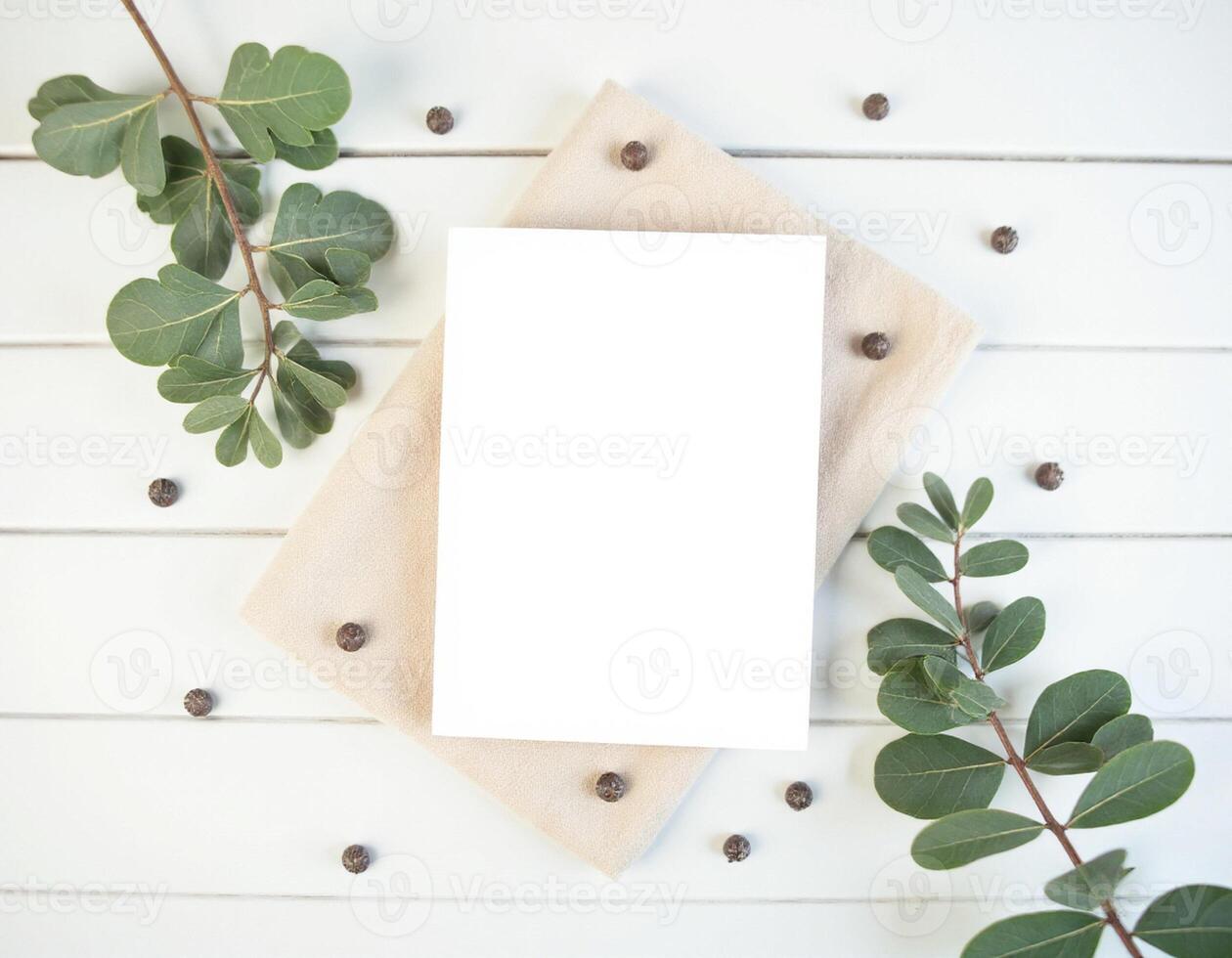 Blank white paper on wooden table with eucalyptus leaves and coffee beans photo