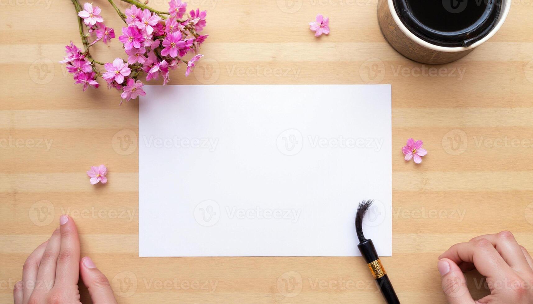 Woman's hands holding a blank paper and a brush on a wooden table with a cup of coffee photo