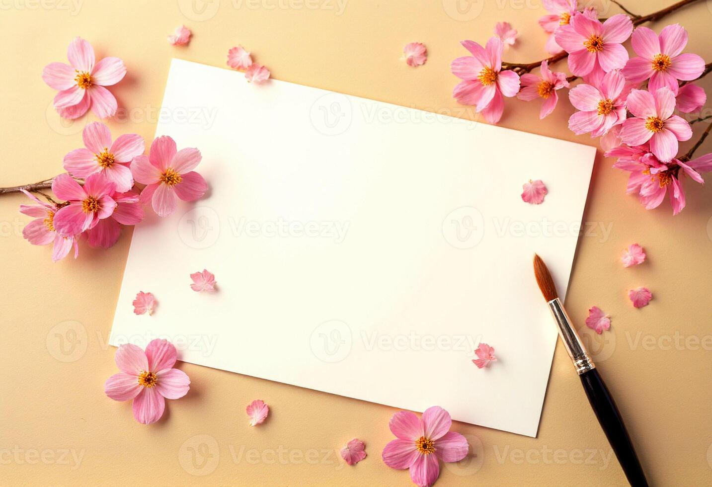 A blank sheet of paper with pink flowers and a brush on a yellow background photo