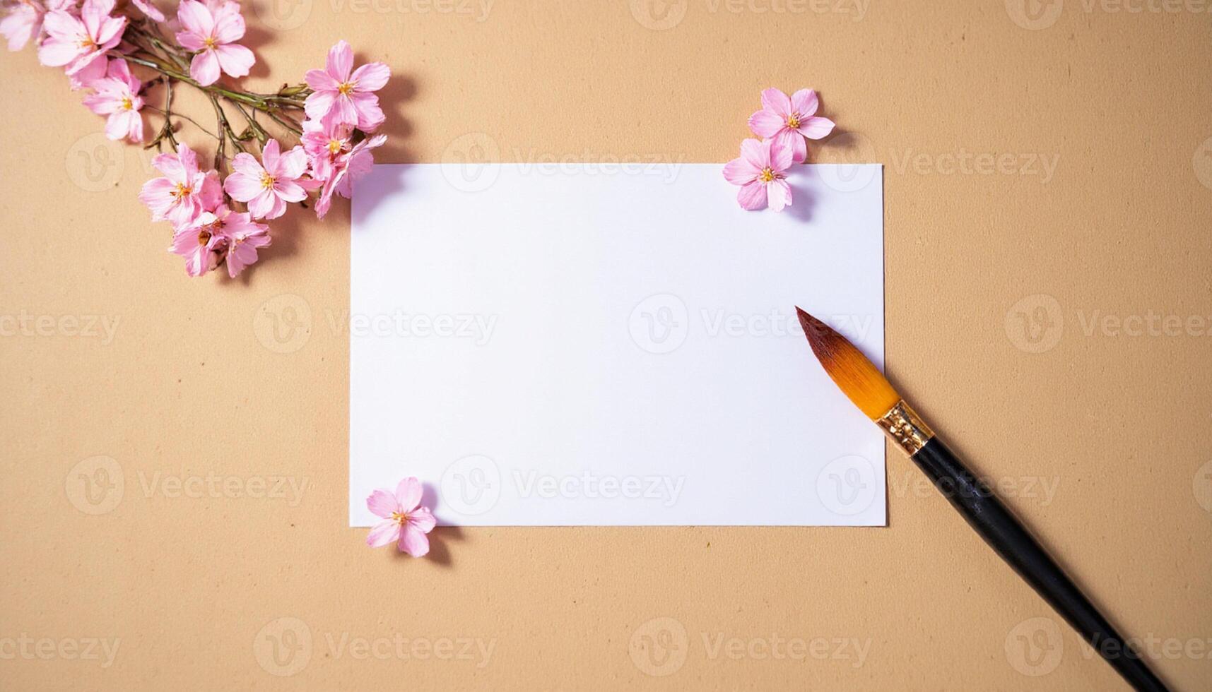 A blank sheet of paper and a paintbrush on a beige background photo