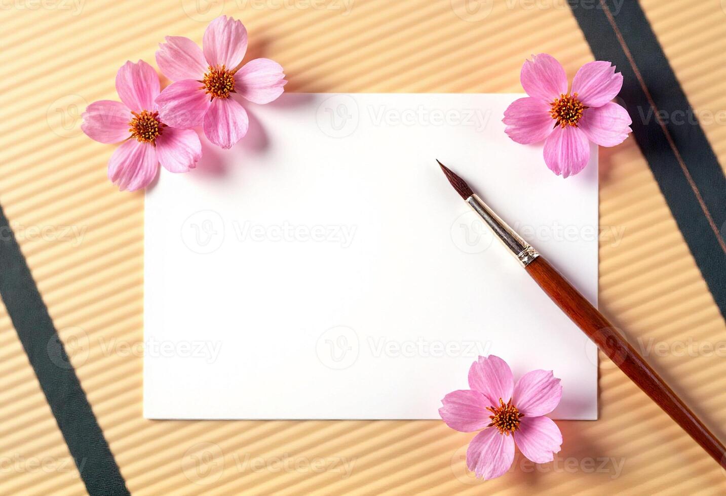 Pink flowers on a note paper with a brush on a wooden background photo