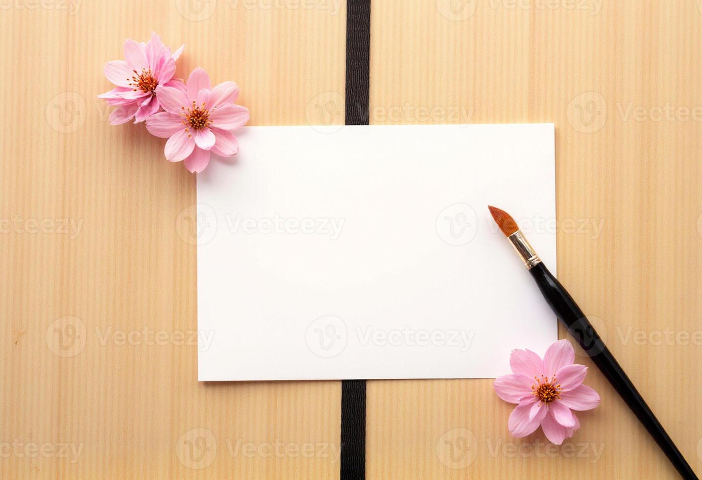 A blank note and a paintbrush on a wooden table photo