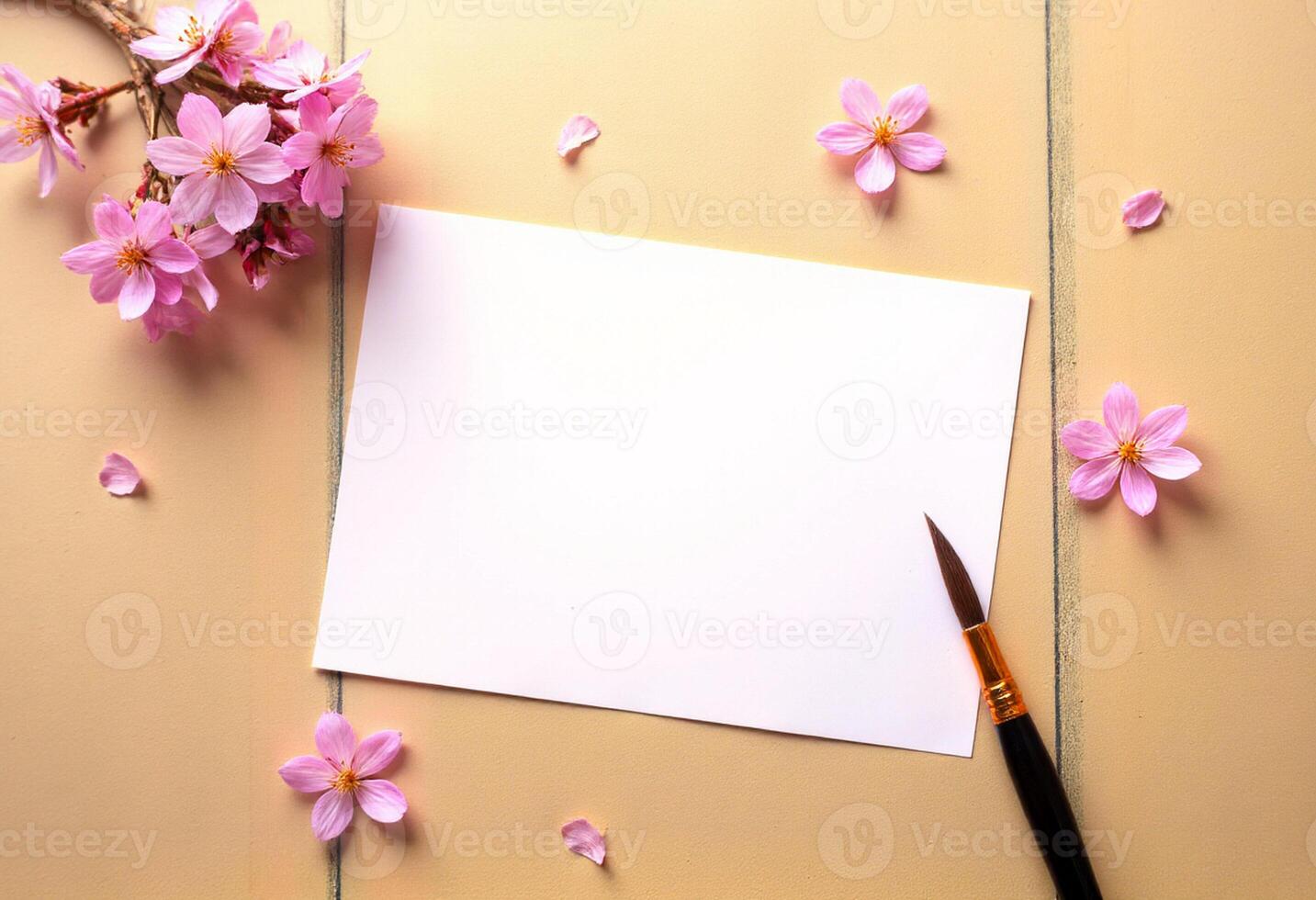 Blank paper and paintbrush on wooden table with cherry blossom photo