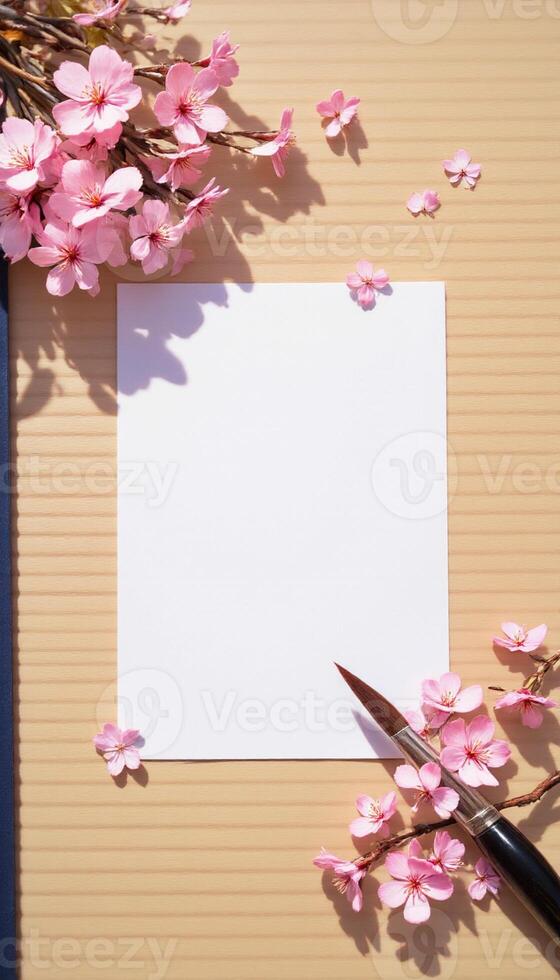 Blank paper, pen and cherry blossom on a brown background photo