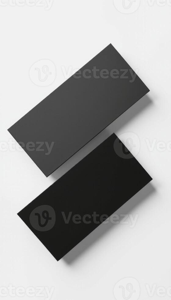 Two black rectangular pieces of paper on a white surface photo