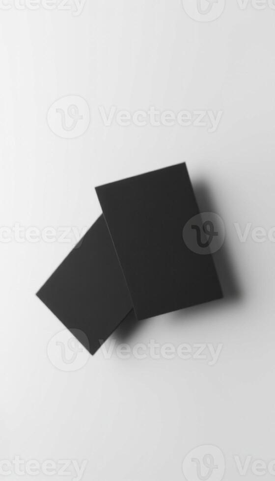 Two black pieces of paper on a white surface photo