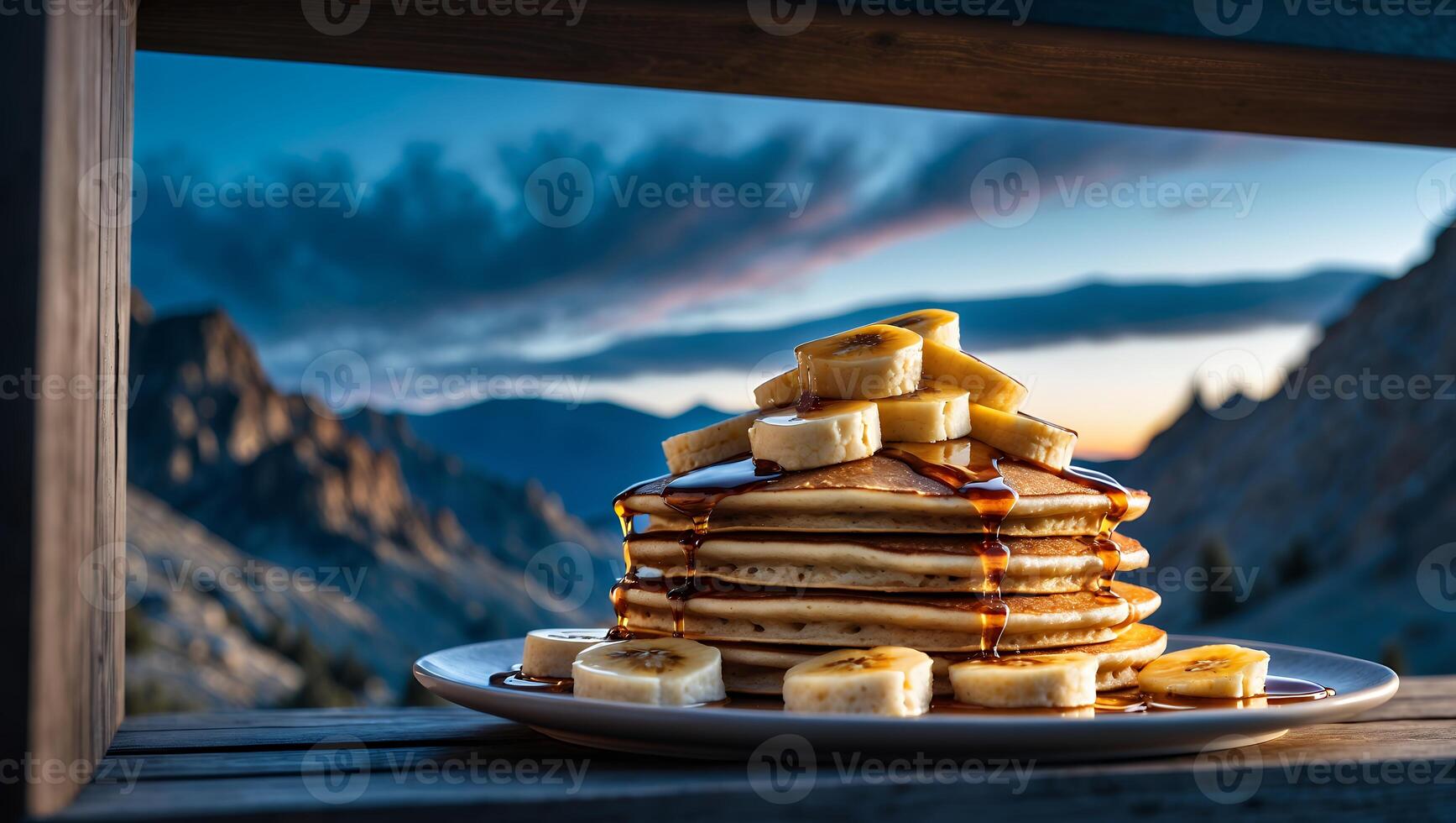 Stack of Pancakes with Banana and Syrup Against Mountain Backdrop photo
