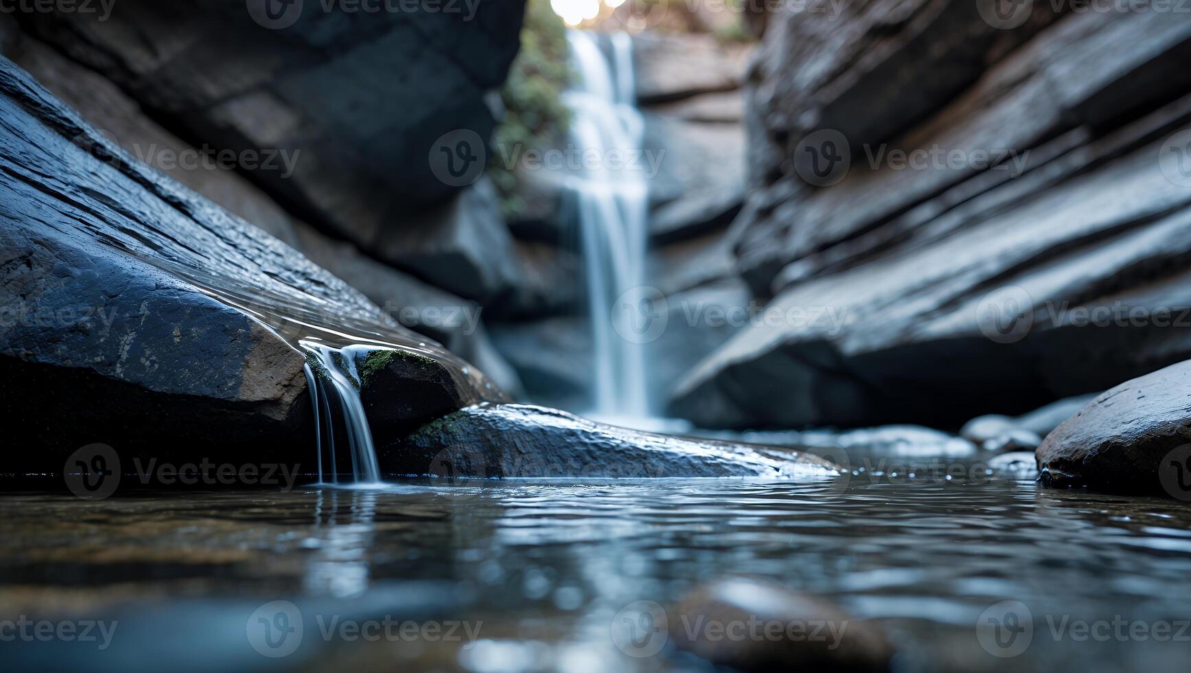 Waterfall Flowing Through Rocky Canyon with Clear Water and Reflections photo