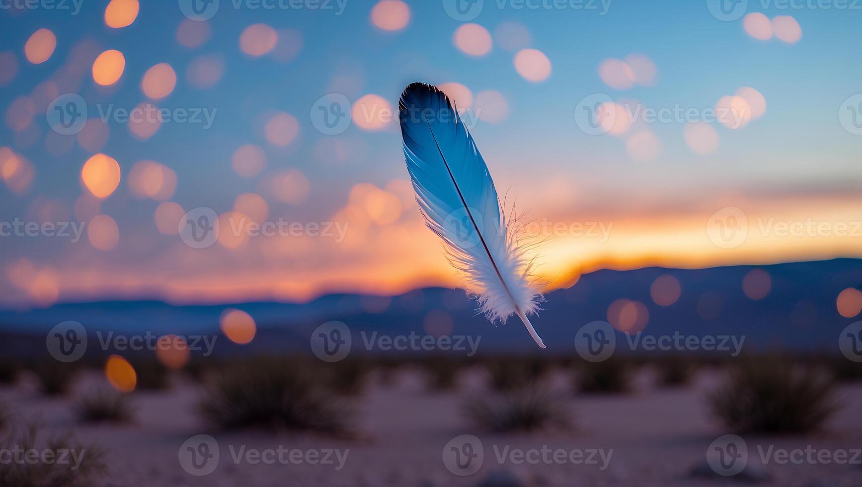Floating Feather Over Desert Landscape at Sunset with Bokeh Lights photo
