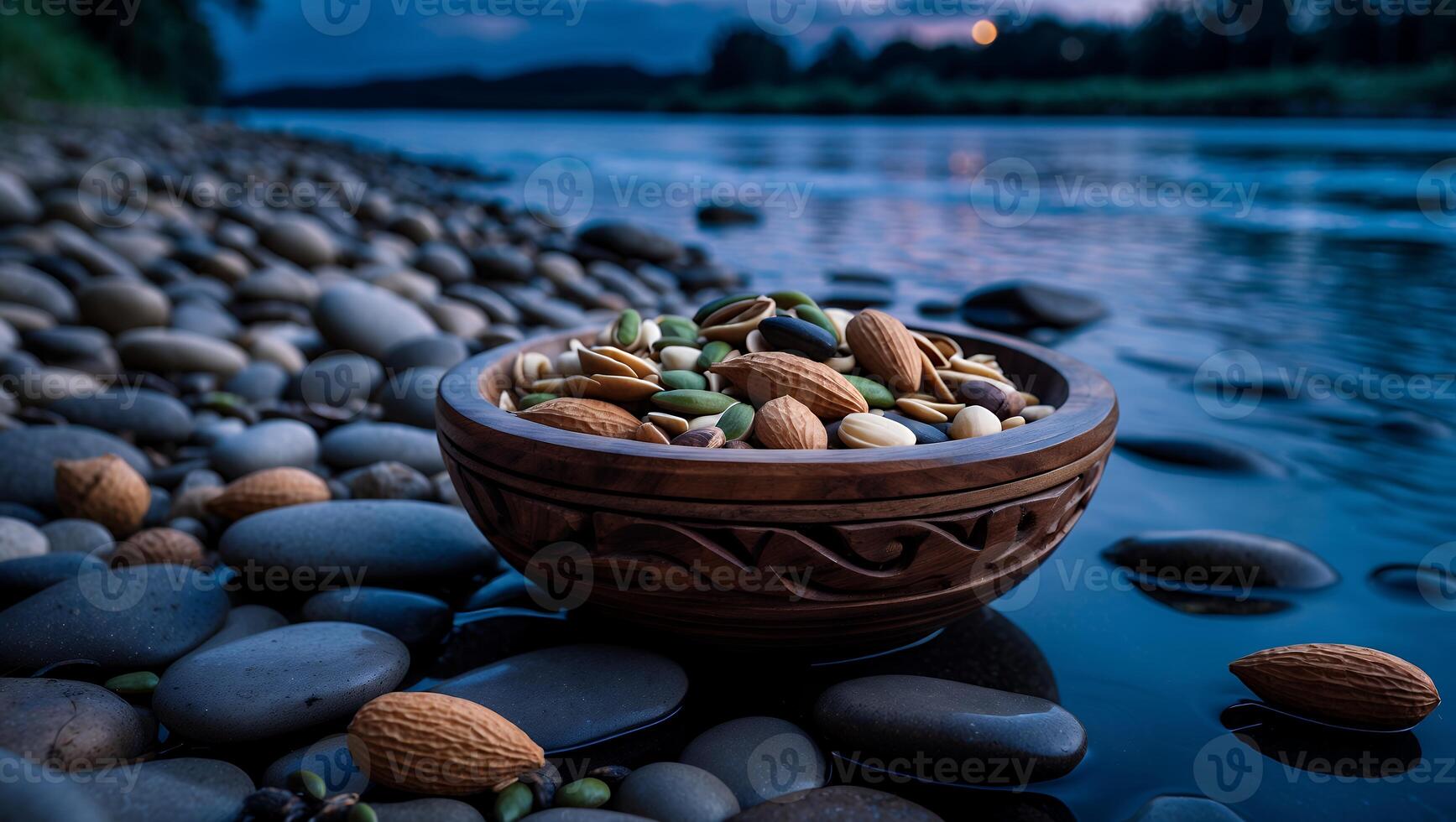 Nuts in Wooden Bowl by Riverbank Rocks at Dusk for Snacking photo