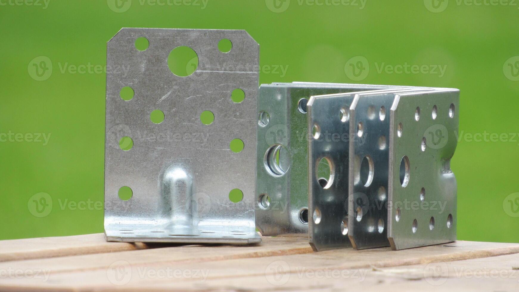 Metal brackets on wooden surface under natural lighting suitable for construction and assembly projects photo