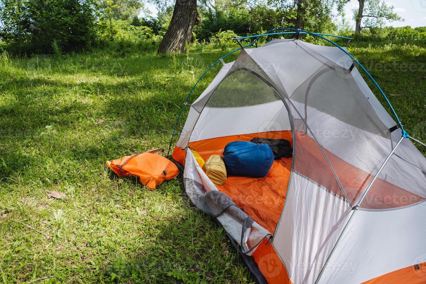 A cozy camping tent setup nestled in a stunning landscape, surrounded by lush greenery and vibrant nature, perfect for an adventurous escape into the great outdoors with friends and family photo