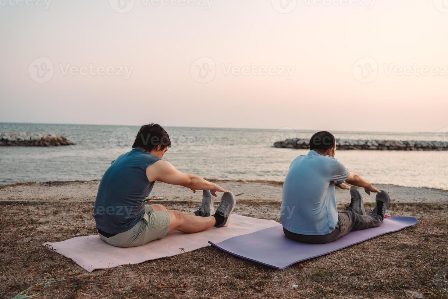 Men doing exercise together and sporty active outside sea beach training active lifestyle. photo