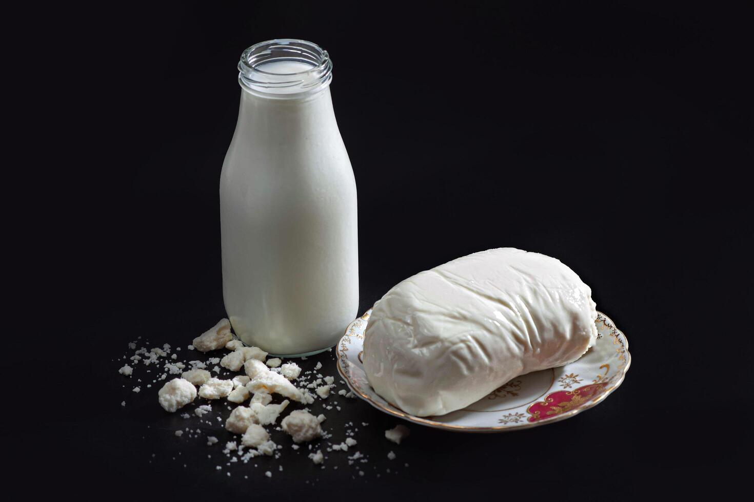 A bottle of milk and a bowl of cheese photo