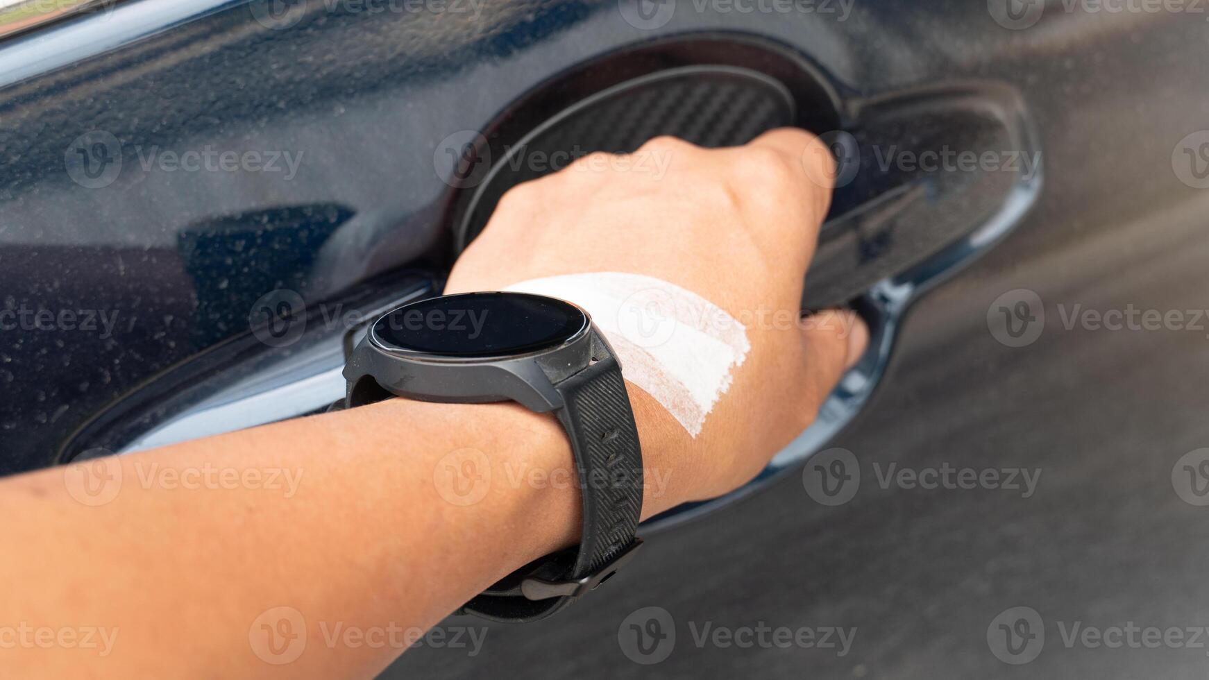 Driver arm has a wound covered with tape on the back of his hand. He wears an old dusty watch. Hold the car door handle to open it. photo