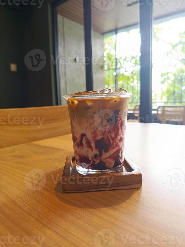 Iced Coffee with Red Fruit Layers on Wooden Table, Cafe Drink photo