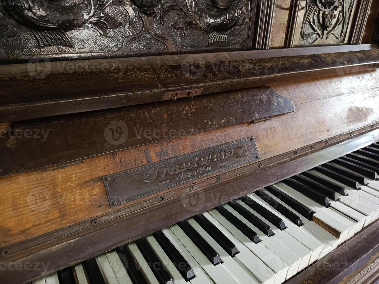 Antique Brown Piano with Black and White Keys and Ornate Wood Ca photo