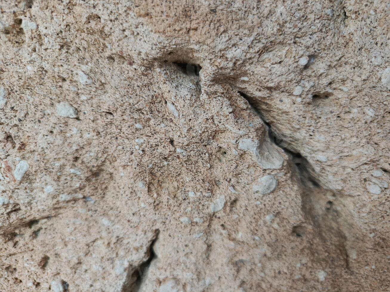 Neutral Textured Rock Surface with Holes and Bumps Close-up photo