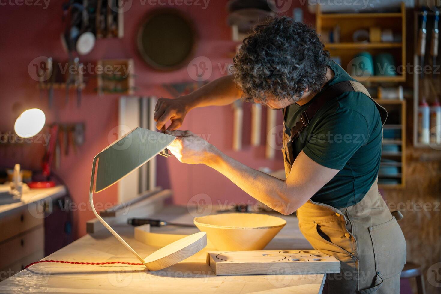 Artisan check lamp dimensions of curved plywood shade with caliper. Woodworker creating custom lamp photo