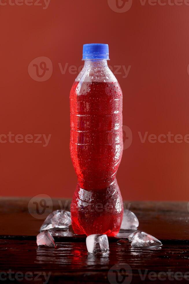Red soft drink bottle with a red background photo
