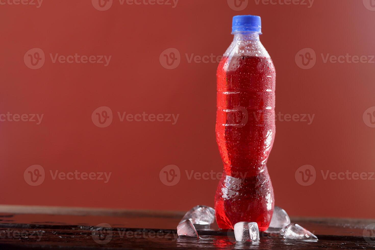 Red soft drink bottle with red background photo