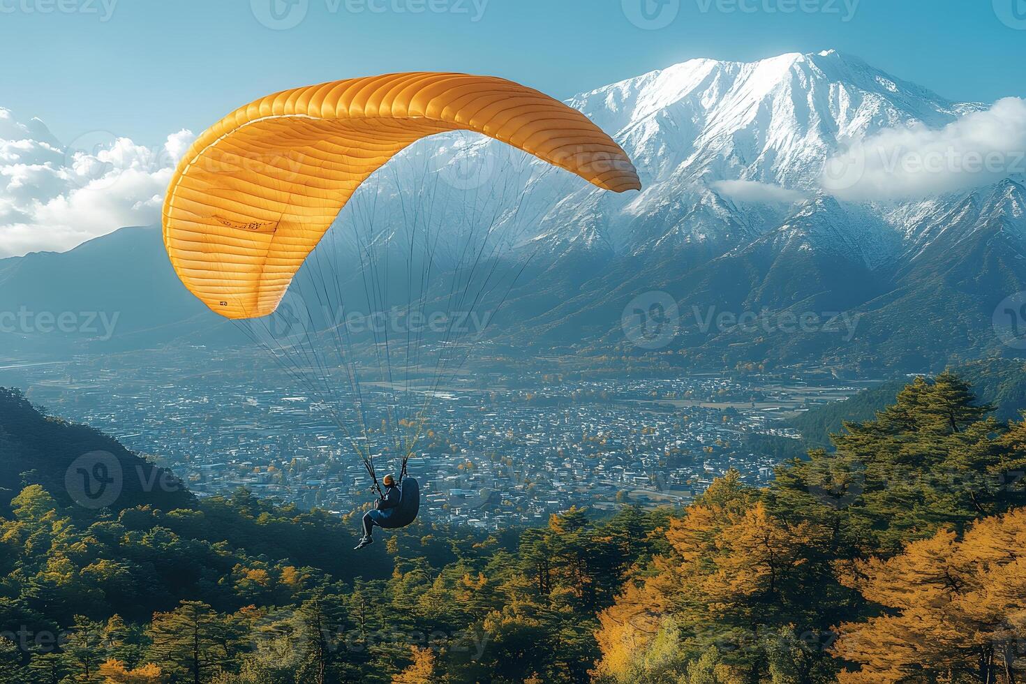 Autumn Paragliding Adventure Over Mountain Landscape and Snow-Capped Peaks photo