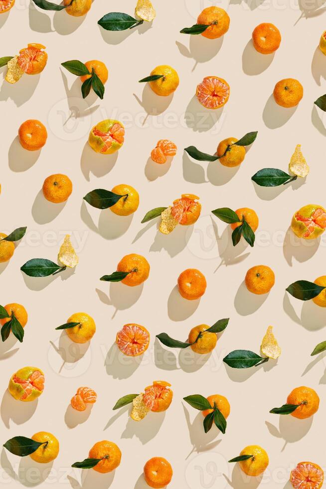 Top view juicy orange yellow tangerines as trend pattern minimal style, Natural citrus fruit with green leaf, light beige background. Organic, healthy, vegetarian and plant-based food, pastel tone photo