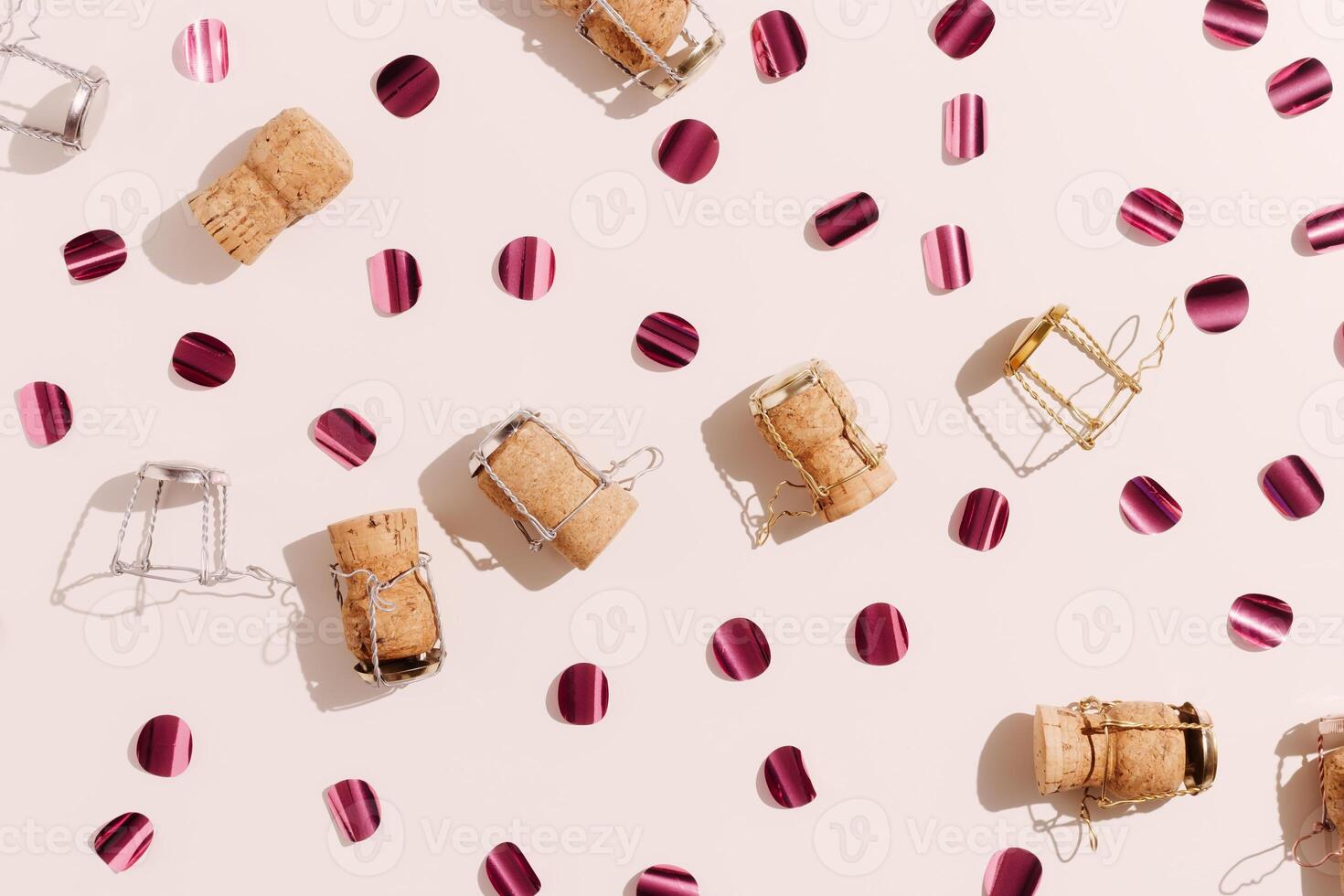 Champagne corks and sparkling confetti, top view composition, holidays, celebration concept. Wooden cork and muselet on pastel background at sunlight shadows. Flat lay festive minimal layout photo
