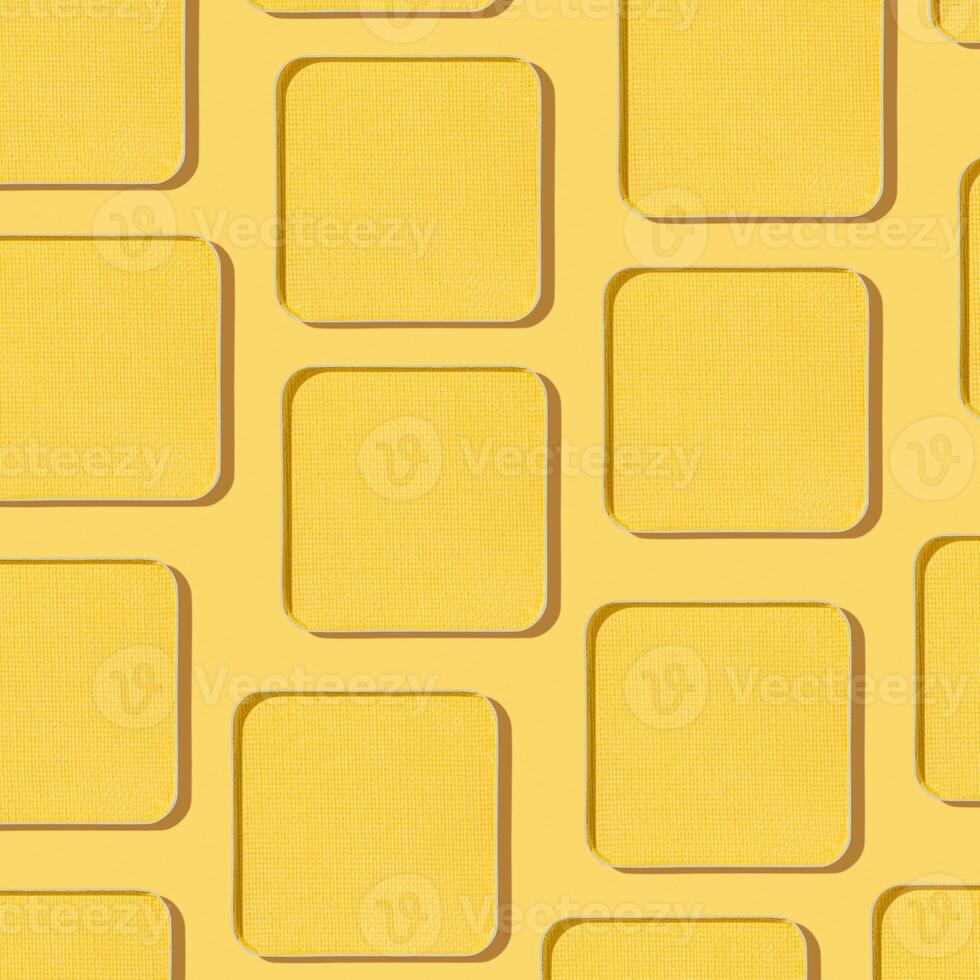 Minimal style pattern eye shadow yellow swatches with shadow, monochrome photoas background, refill compact eyeshadow, shiny colored powder for makeup, square shape metal pack, cosmetic texture photo