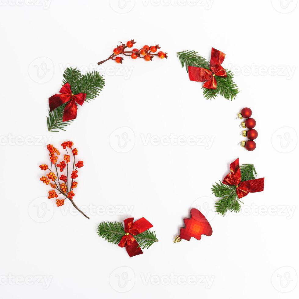Christmas round frame from natural green fir branches and small red glitter balls and berries o photo