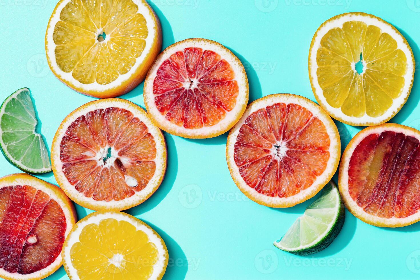 Composition with slices citrus fruits, grapefruit, red orange, lemon, lime on turquoise. Summer food flat lay photo